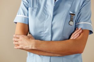 A nurse with their arms crossed.