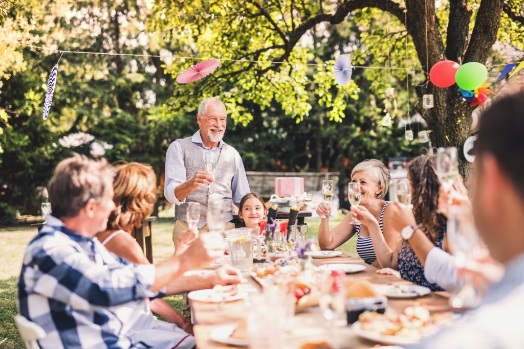 Family sat around a large table celebrating.