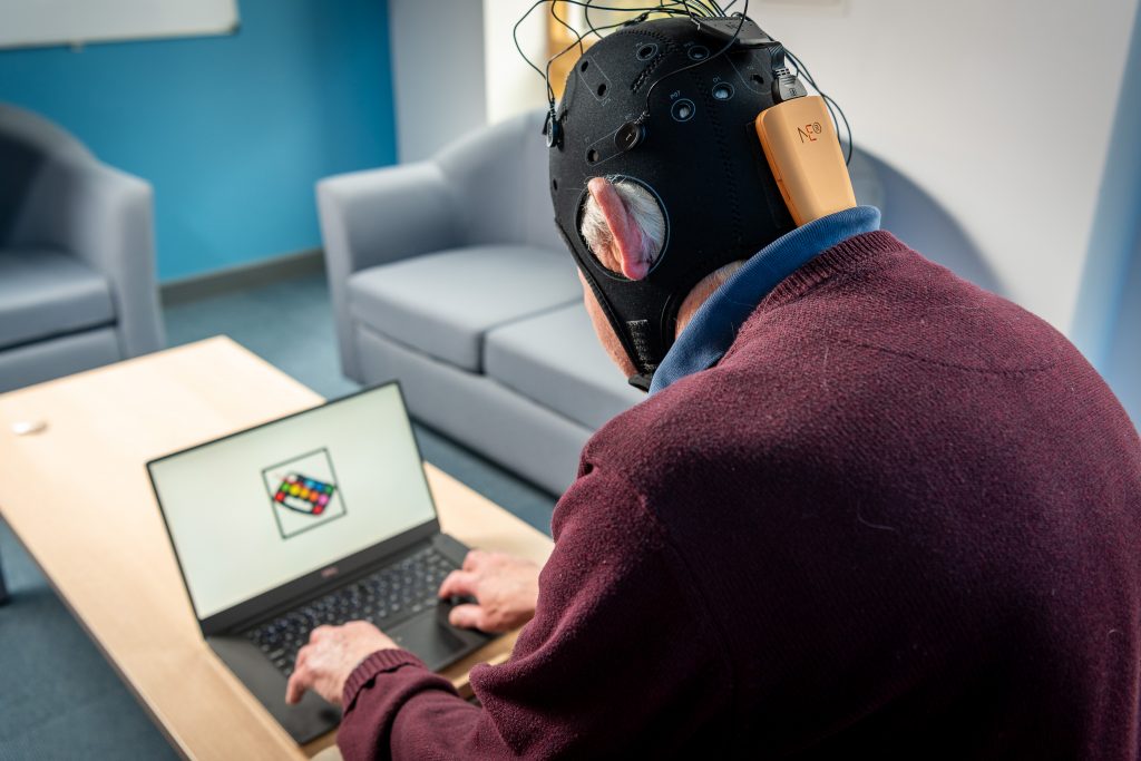 Psychology Research Shoot Man with EEG cap on watching a laptop with flashing images.