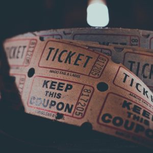 A roll of old fashion cinema tickets on a table with a dark background.