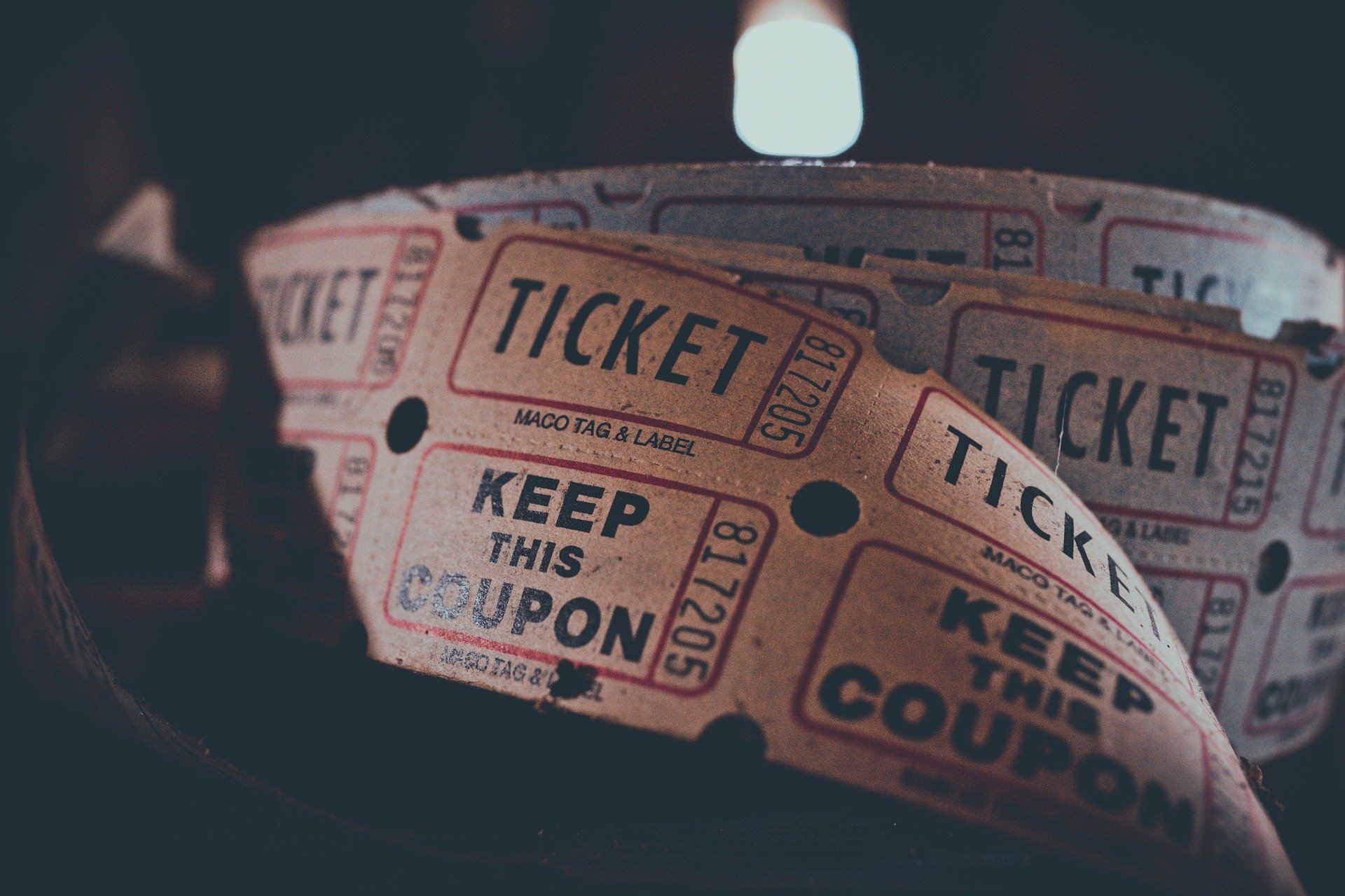 A roll of old fashion cinema tickets on a table with a dark background.