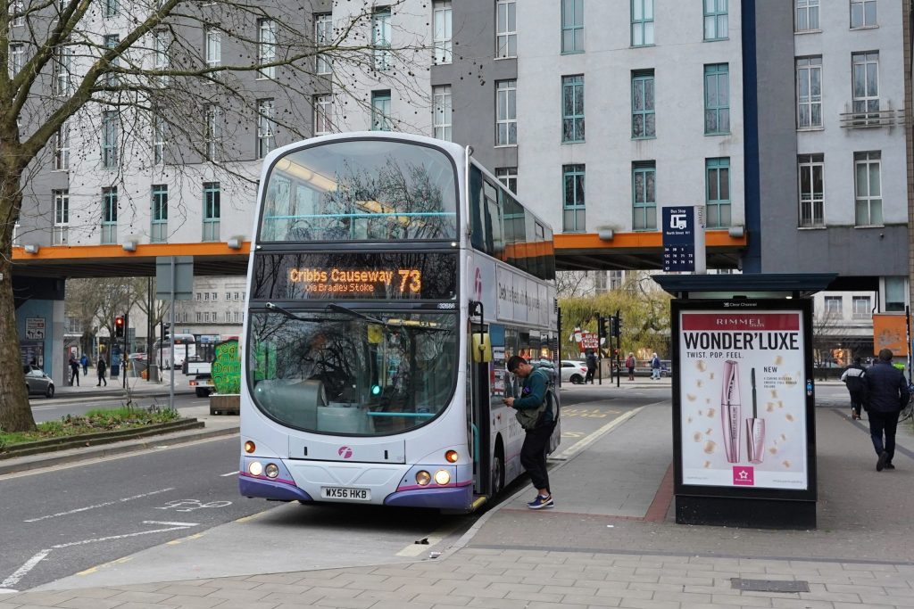 A Bristol number 75 bus is stopped at a bus stop on a main stretch of round in the city centre.