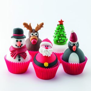Five Christmas cup cakes. A snowman, a reindeer, Santa Claus, a penguin and a Christmas tree.