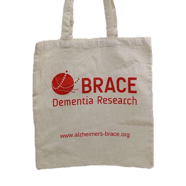 A white tote bag with red text. The text says BRACE Dementia Research and the BRACE website.