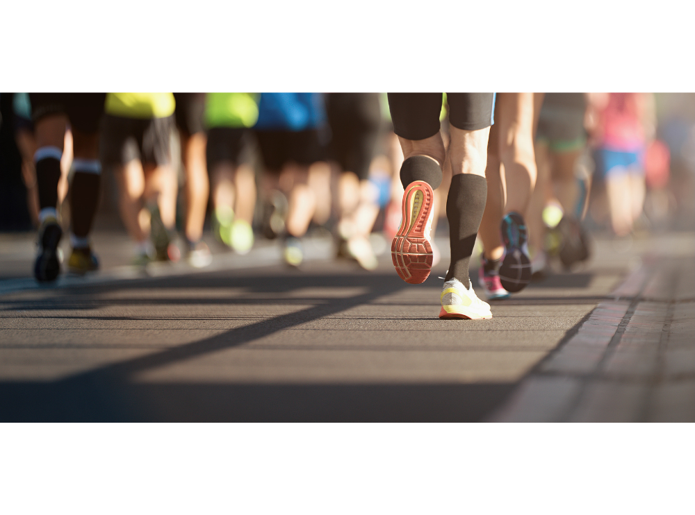 Lots of runners legs taking part in a race, you cannot see above their thighs.