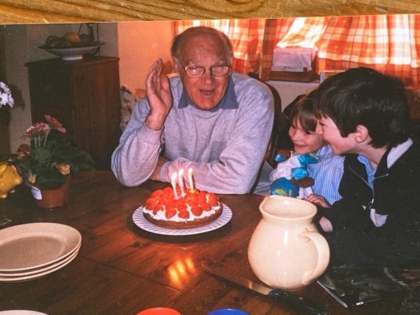 Grandad and Elise Grandad and Elise sat to a table with a birthday cake.