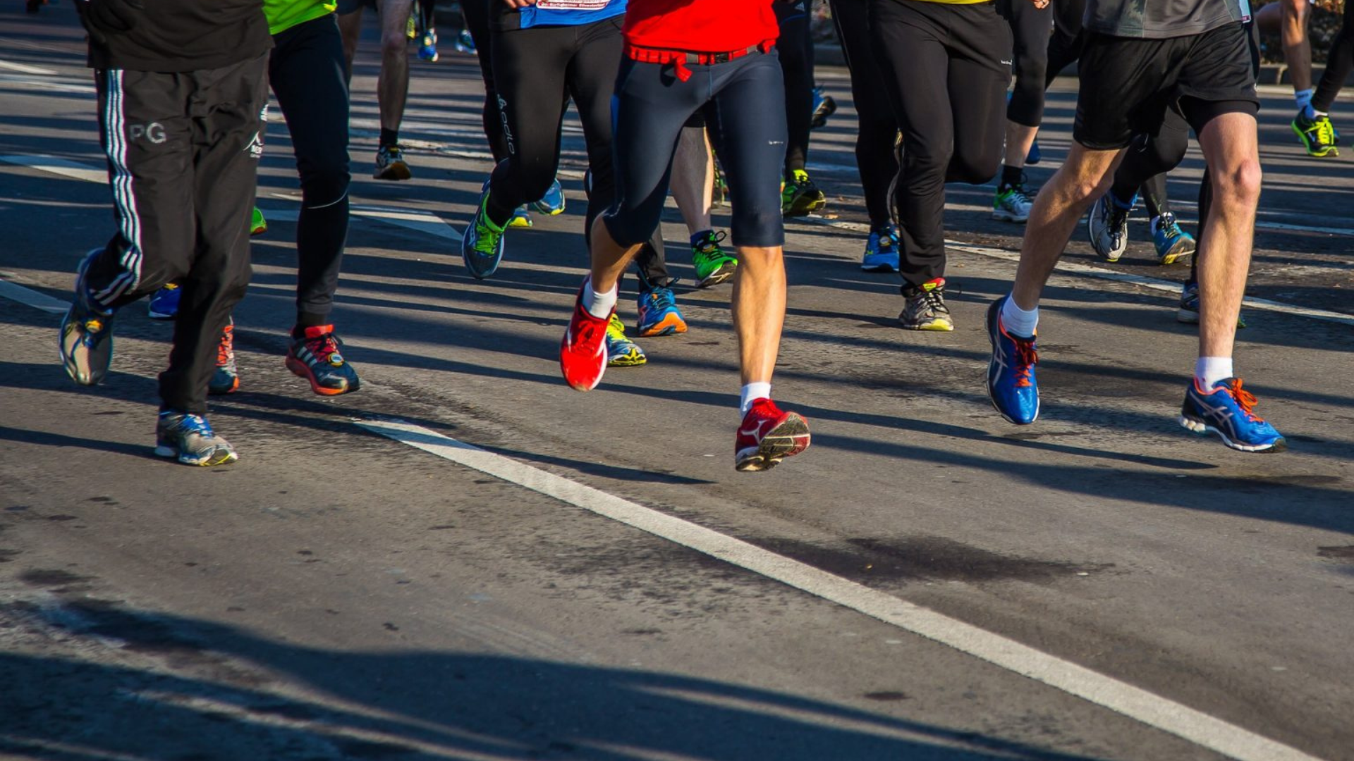Lots of runners legs taking part in a race, you cannot see above their thighs.