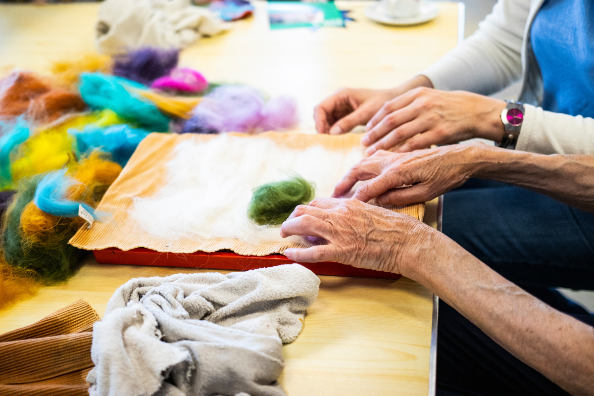 Someone is using their hands to make felt art.