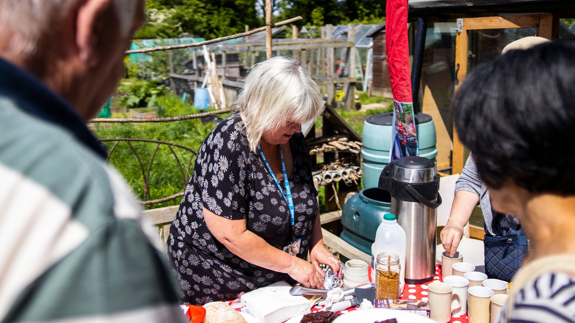 A woman makes mugs of tea and coffee for attendees at the Alive Allotments.