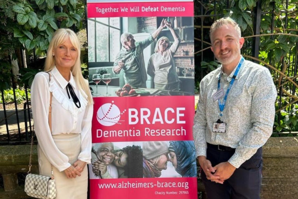 Jayne Connery and Chris Williams are stood next to a BRACE banner.