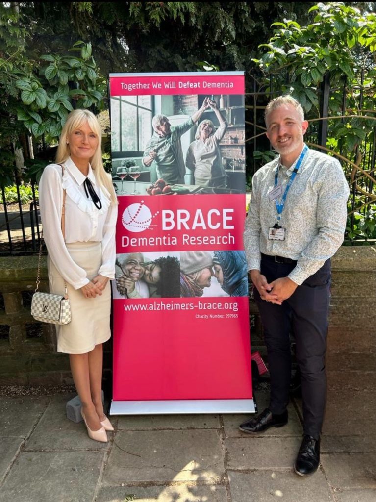 Jayne Connery and Chris Williams are stood next to a BRACE banner.