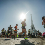 Runners taking part in the Paris marathon, they are running past the Eiffel Tower.