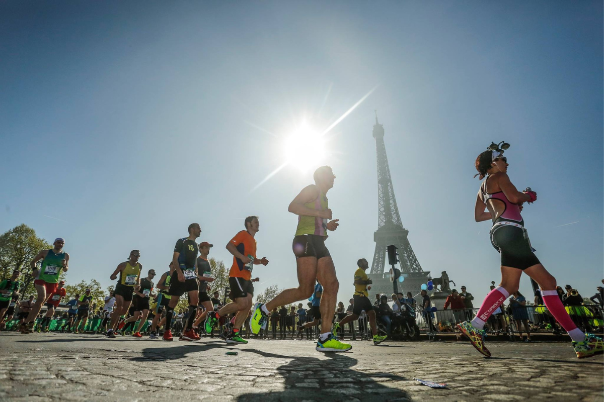 Runners taking part in the Paris marathon, they are running past the Eiffel Tower.