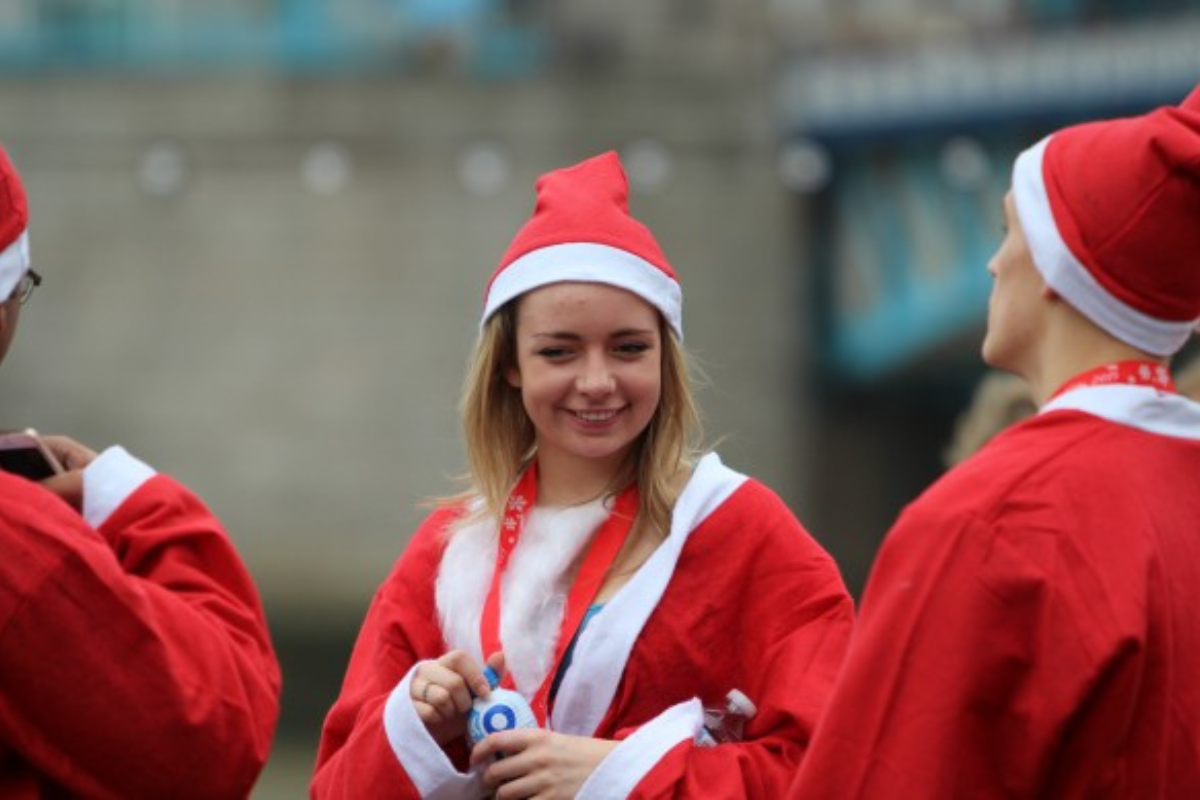 A woman is dressed up as Santa.