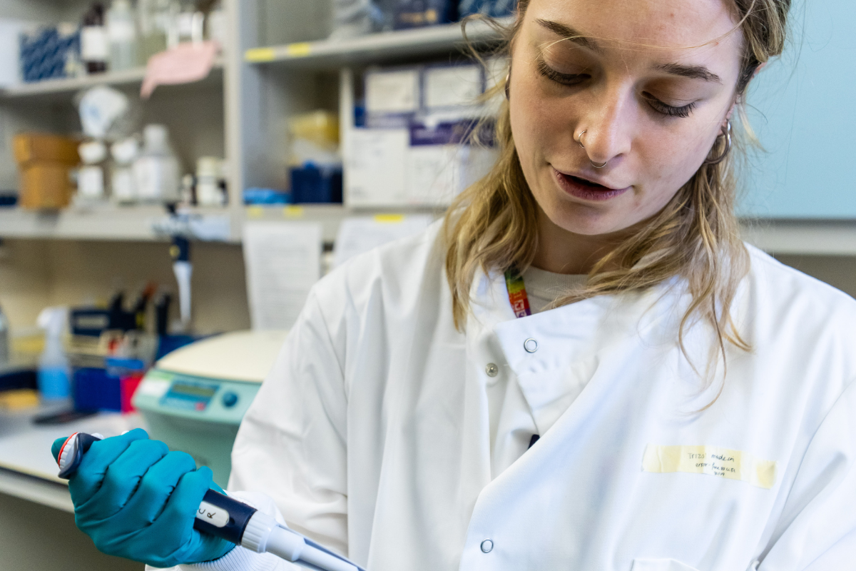 Why we fight appeal 1/2 day of research A scientist in a lab coat with a large pippett
