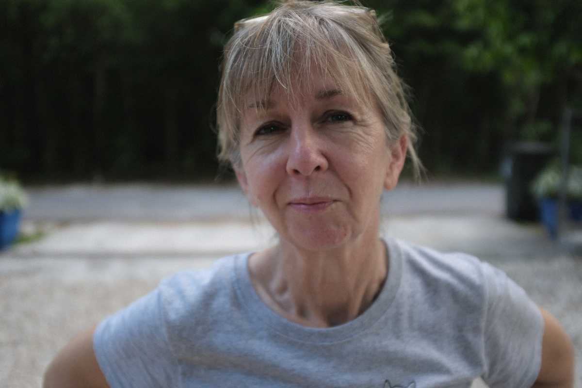 A woman in her late 50s-early 60s. She has grey hair.