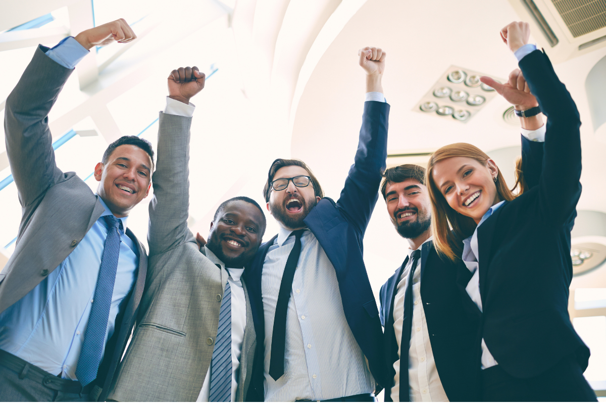 A group of office workers in suits cheering.