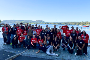 A big group of people from Capital One in front of a lake.