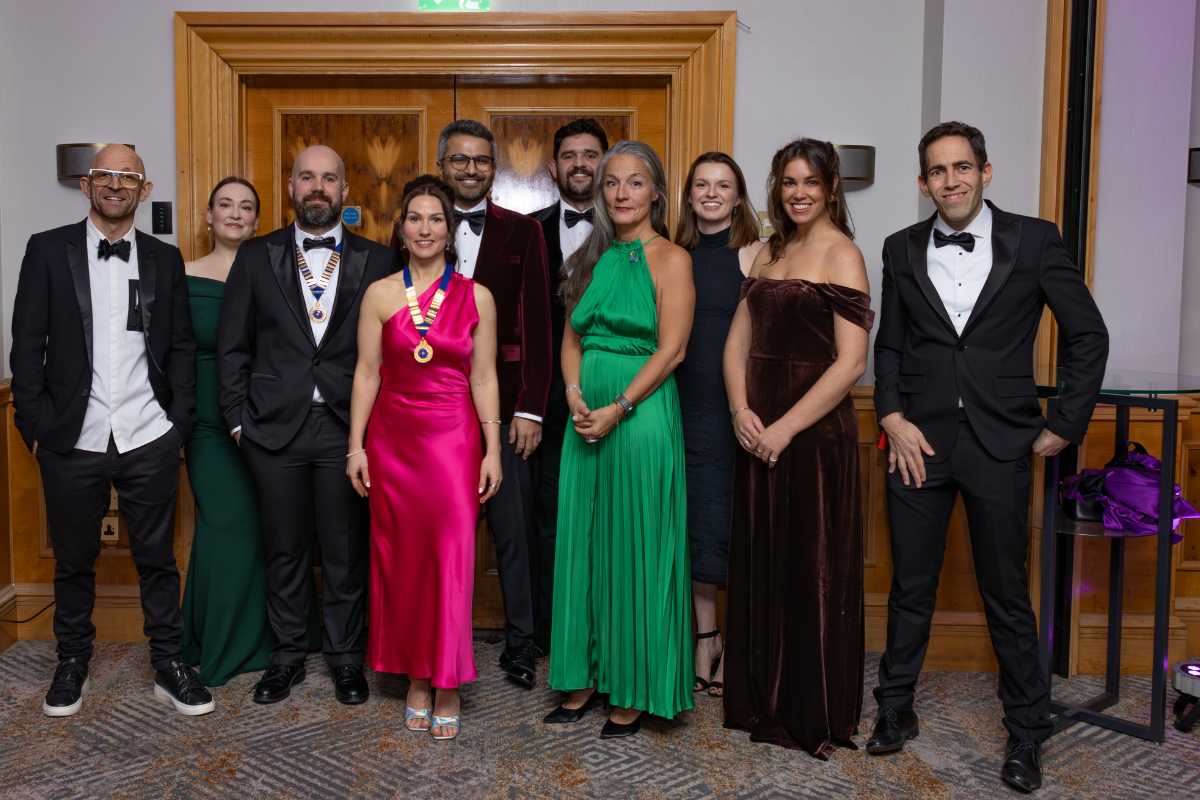 A group of people standing at a gala, smiling at the camera.