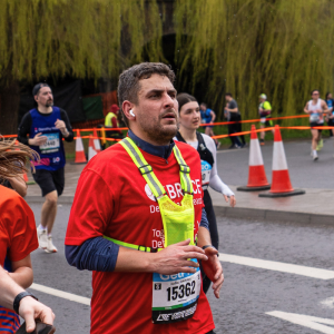 A BRACE runner wearing red a BRACE running top at the Bath Half Marathon.
