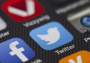 Social media icons on a phone, Facebook and Twitter.